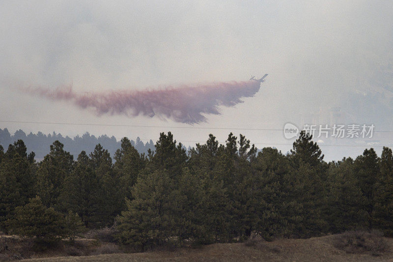 消防飞机在科罗拉多州博尔德冒烟的NCAR上空喷洒泥浆