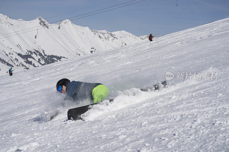 男子在滑雪板上切割滑雪坡