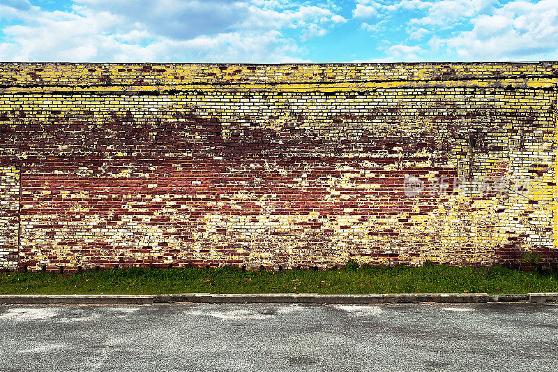 腐烂的黄砖墙，小镇，城市道路，停车场，复制空间，空置的废弃建筑