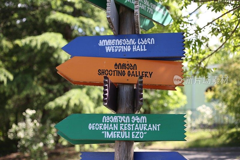 游乐园里的木制标牌，有英语和格鲁吉亚语