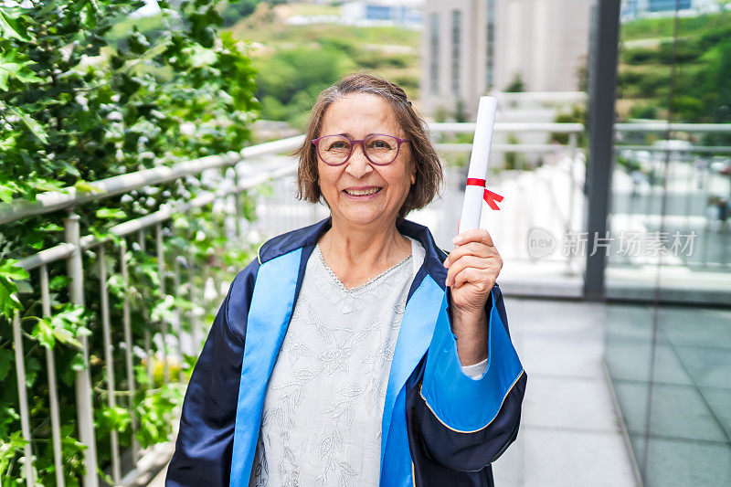 快乐和自豪的年长妇女从大学毕业，并持有她的文凭