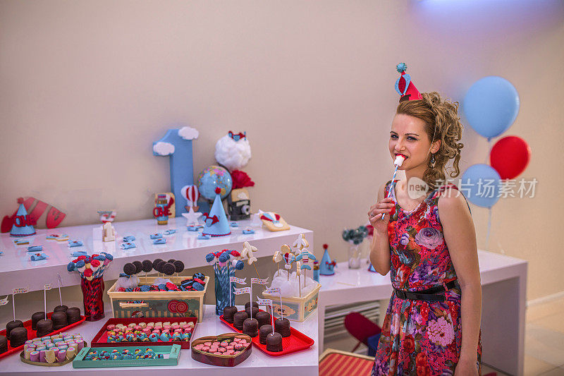一个女人在她的生日聚会上选择先吃什么糖果