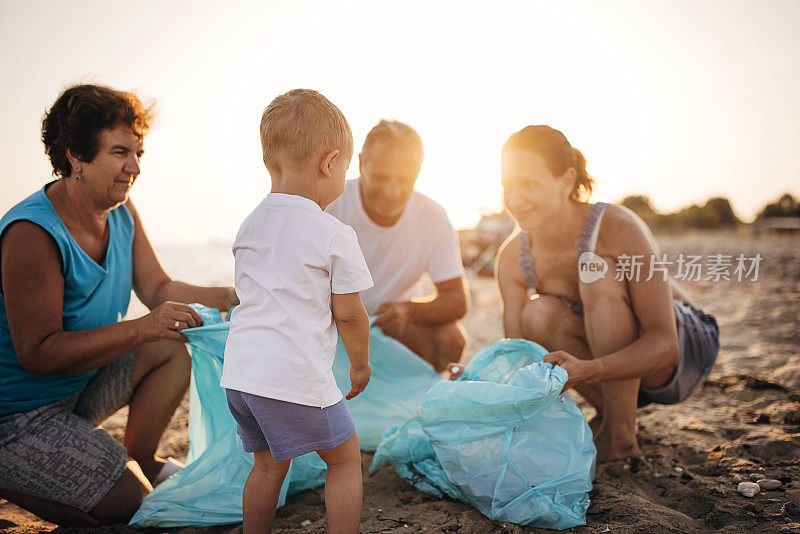 多代同堂——母亲，儿子，祖父和祖母，在海滩上捡垃圾