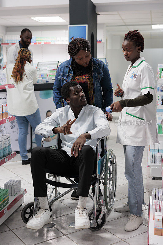 药剂师向轮椅上的非裔美国顾客讲解维生素