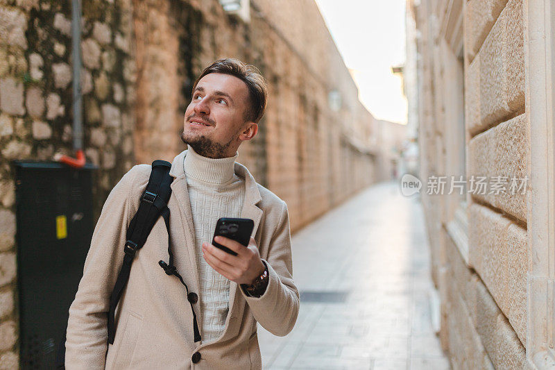 年轻男性游客在游览杜布罗夫尼克老城区时使用手机