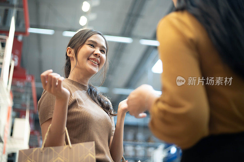 两个亚洲女孩在购物中心购物时和你聊天