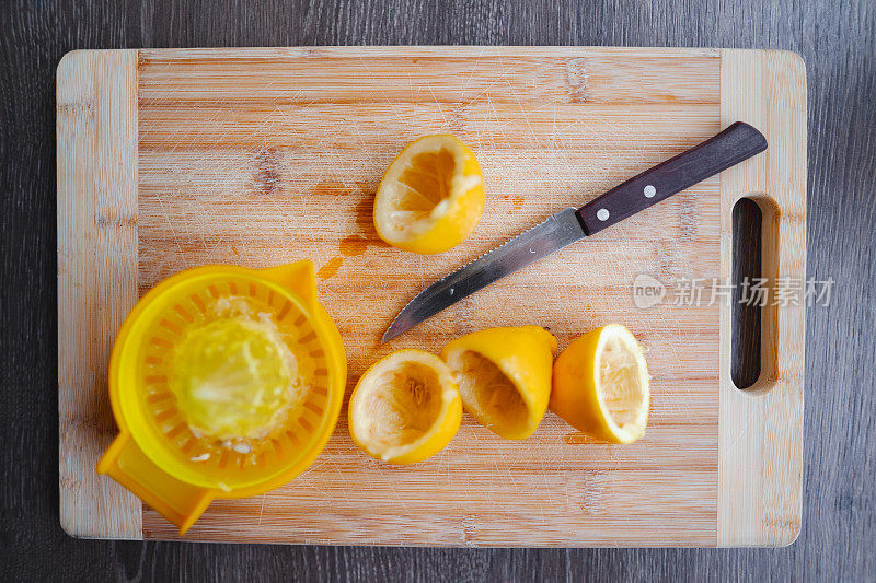 把柠檬和果汁挤成两半，放在砧板上