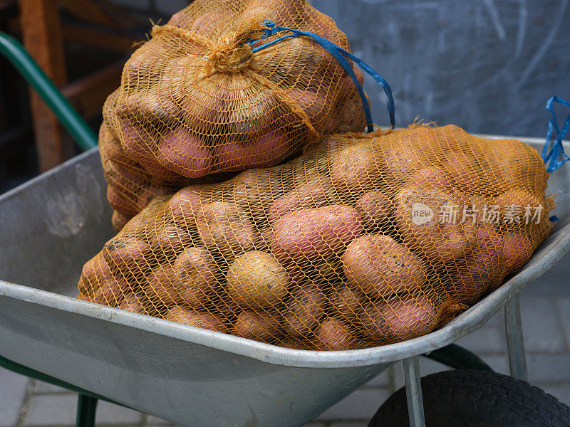一辆手推车里装着大袋的土豆
