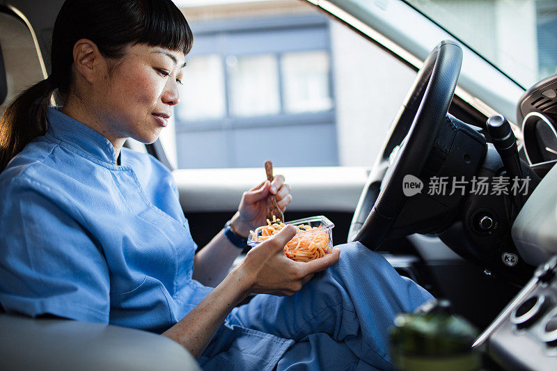 年轻的日本医护人员在车里吃午饭