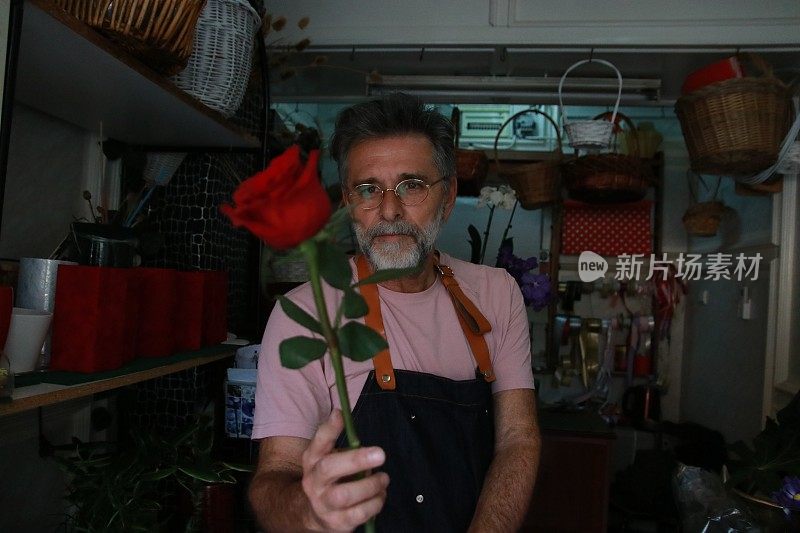 留着胡子的男人手里拿着玫瑰花