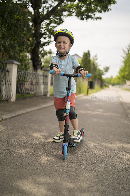 小男孩骑摩托车。孩子们玩滑板