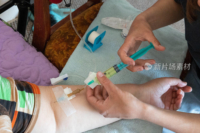 护士在家里通过静脉滴注给病人静脉注射药物。