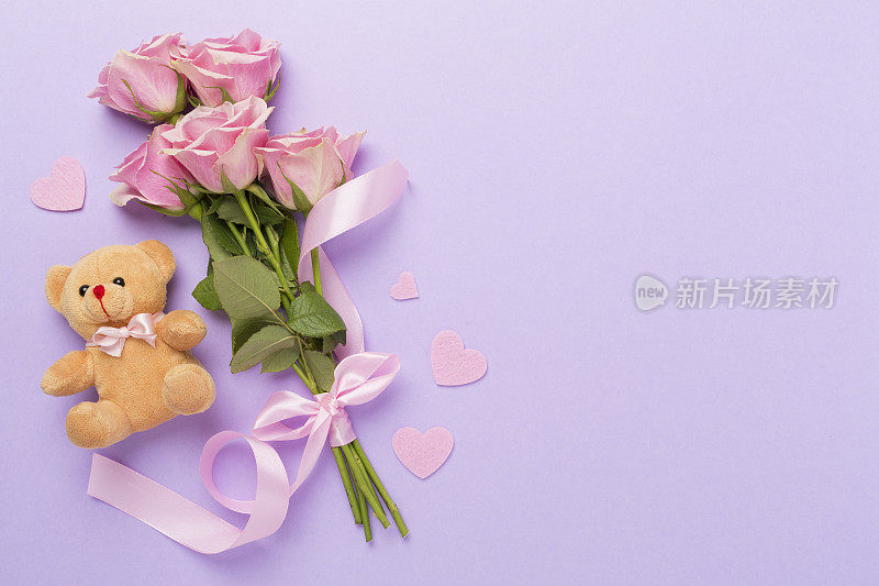 粉红色玫瑰与心和礼盒的颜色背景，俯视图。情人节概念