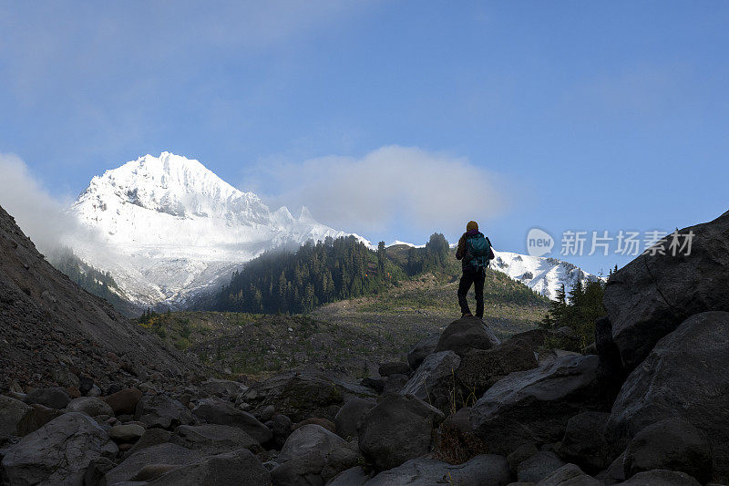 徒步旅行者在雪山下的山脊上休息