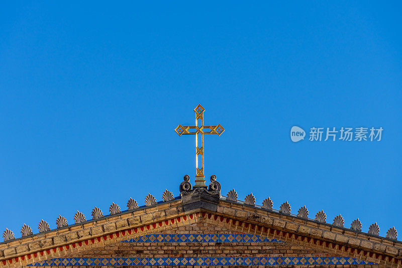 教堂屋顶上的基督十字架映衬着晴朗的天空
