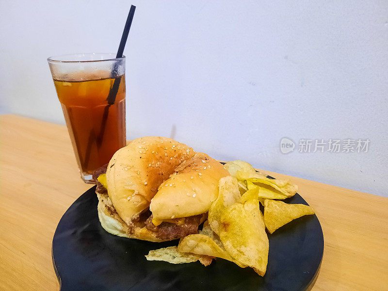 一片美味的安可汉堡配薯片和凉茶。食物和饮料菜单。