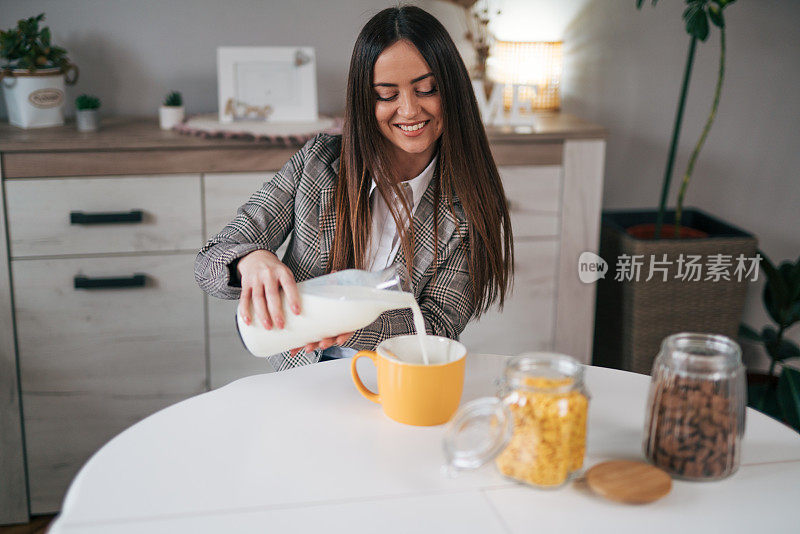 一位女士为早餐倒牛奶