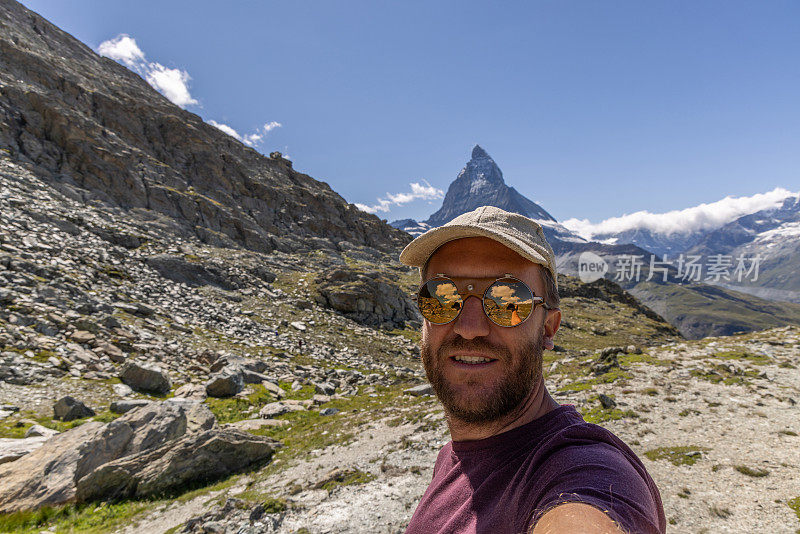 一名男子在瑞士采尔马特自拍，背景是马特洪峰