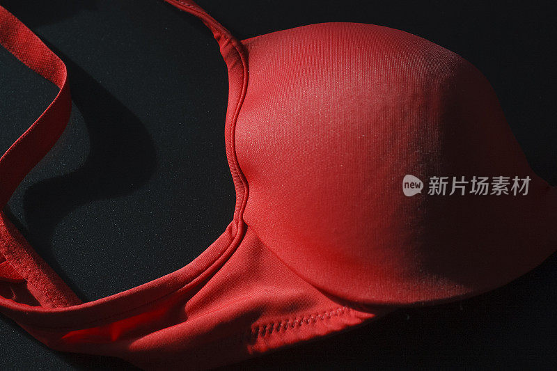 近景拍摄的现代经典性感的红色无缝无缝光滑无衬里豪华优雅的女性胸罩在黑色的背景。