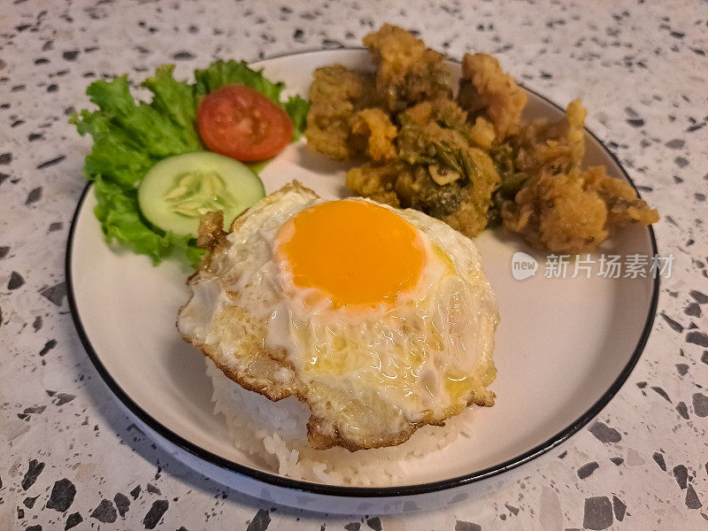 美味的青椒炸鸡配米饭，鸡肉，煎蛋，生菜，番茄片和黄瓜片。食品菜单。