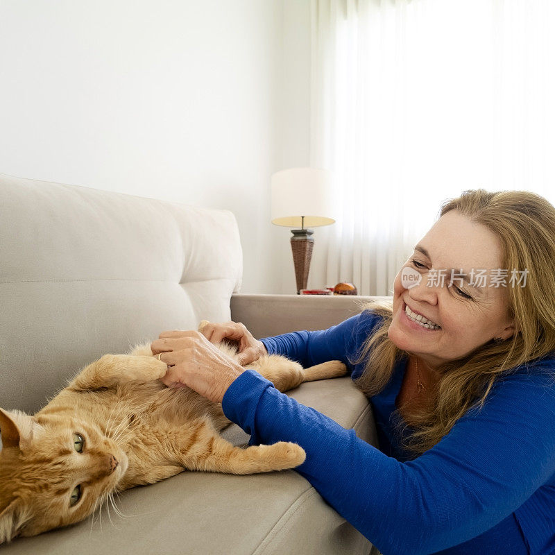 女人和他的姜黄色猫在家里。