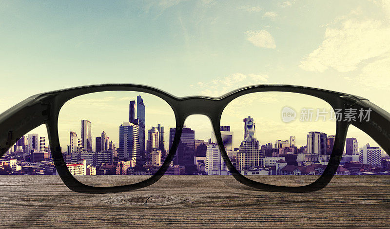 太阳眼镜在木桌与城市景观背景