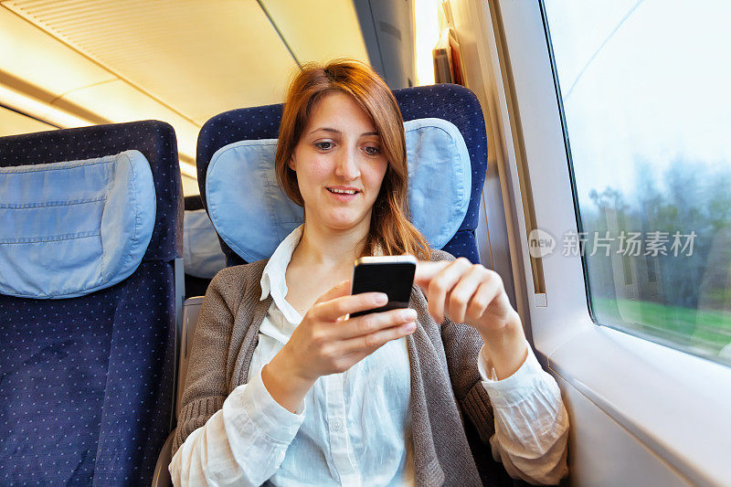 年轻女子在火车上看手机