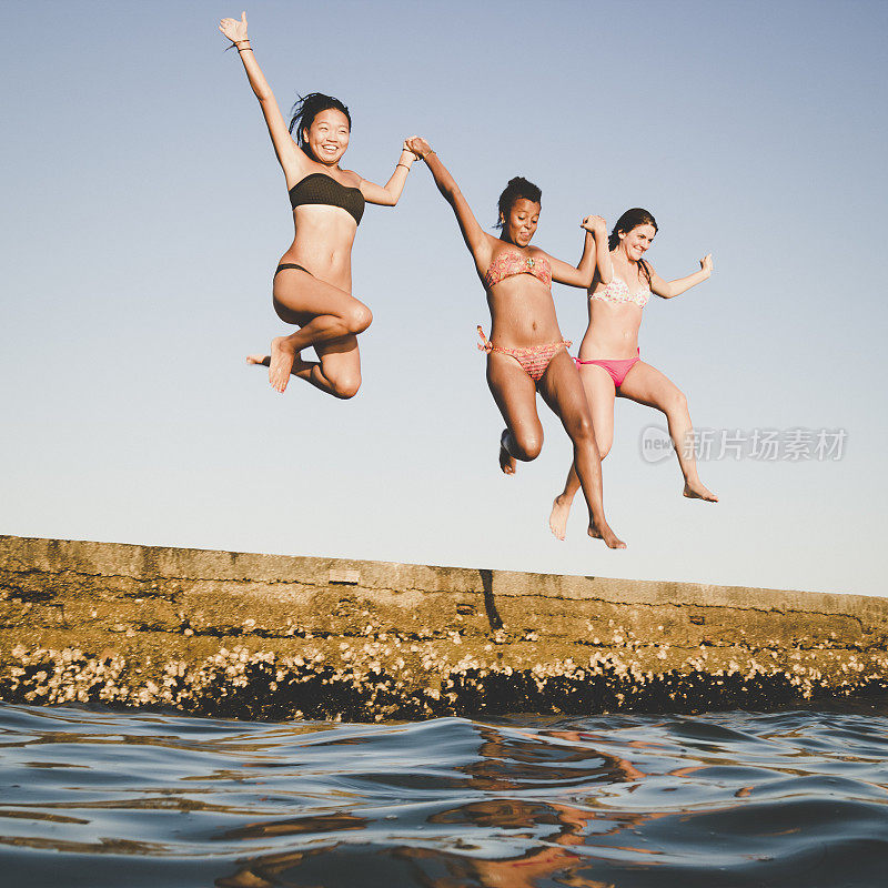 三个女人在夏天跳进海里