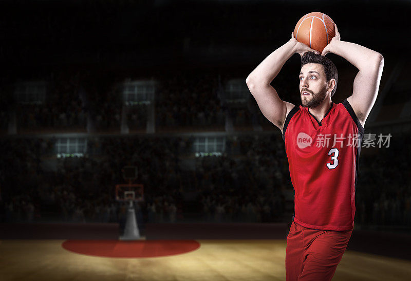 篮球运动员在篮球场上穿着红色制服