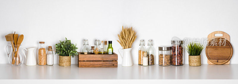 厨房架子上有各种香草，香料，器皿在白色的背景