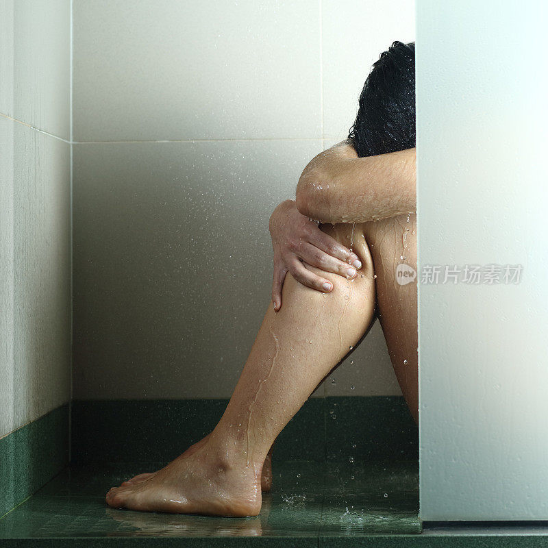 悲伤的女人在淋浴后被虐待