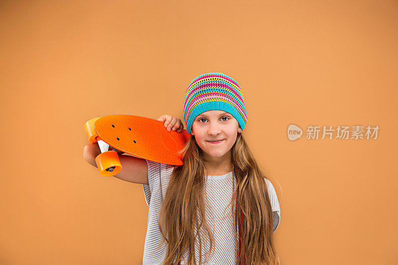 漂亮的滑板女孩拿着滑板