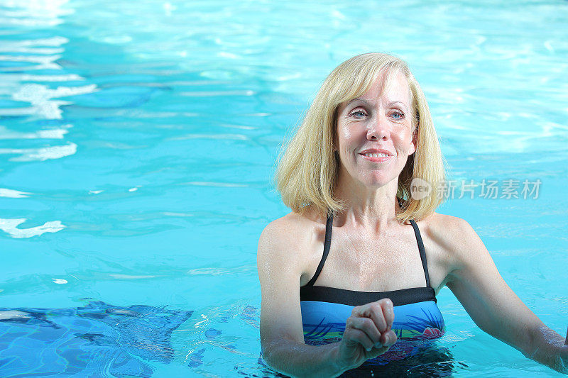 迷人的白人年长女士在游泳池做水上运动
