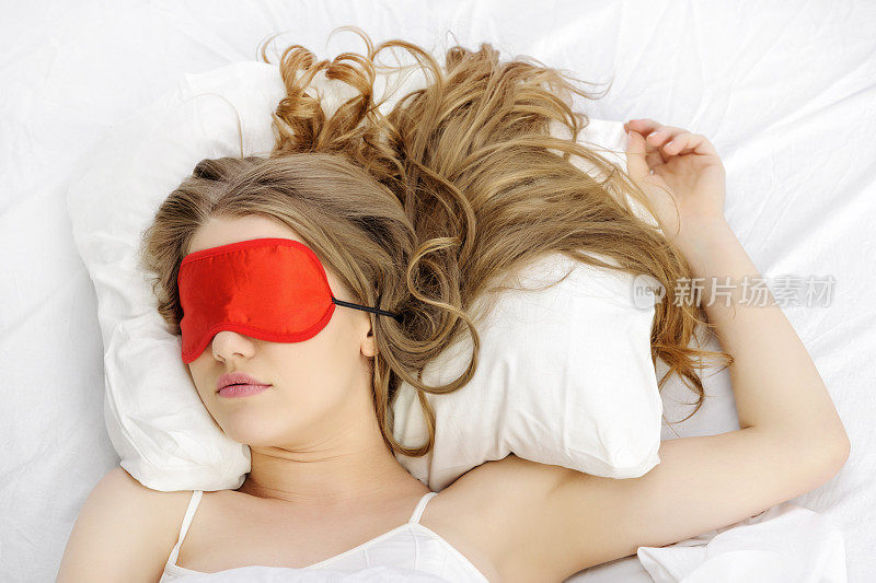 女人躺着，戴着睡眠面具