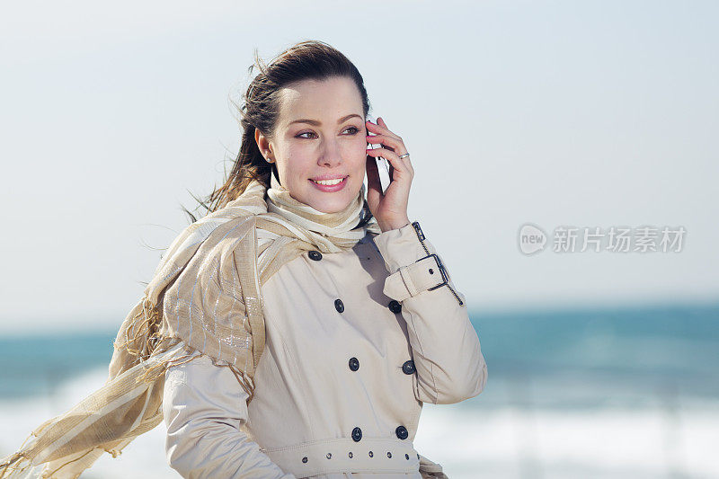 一名年轻女子在地中海海滩上使用手机