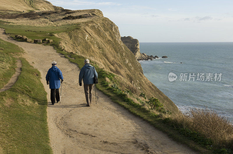 一对老年夫妇在英国多塞特海岸小径上散步