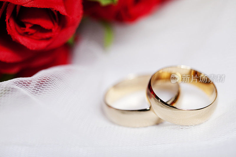 结婚戒指和红玫瑰花束