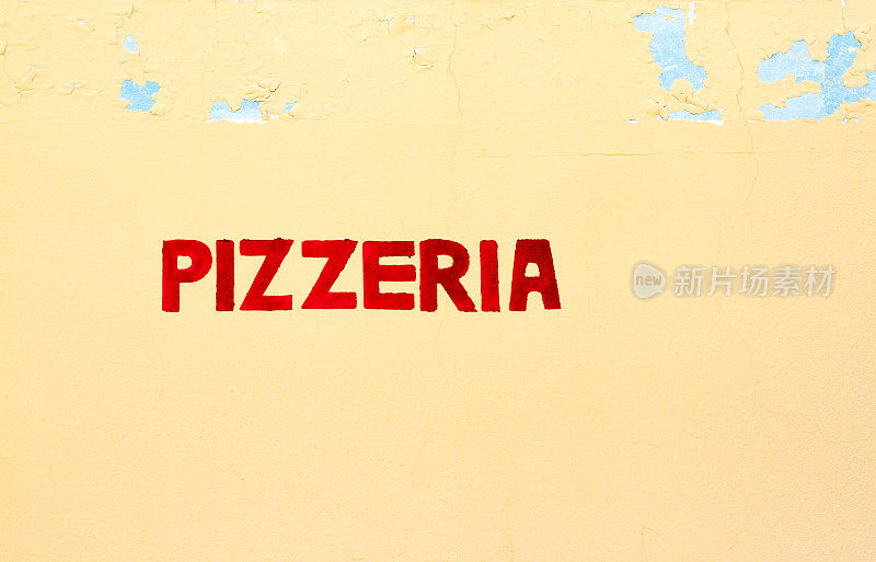 意大利老黄墙上的红色“披萨店”字样