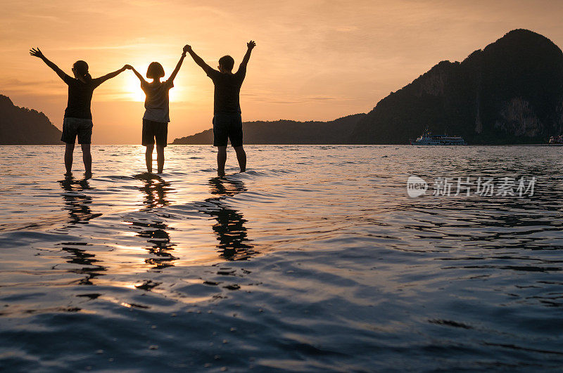 幸福的一家人在海滩上散步