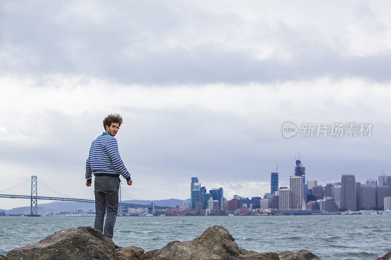 年轻的潮男站在旧金山的景色前。