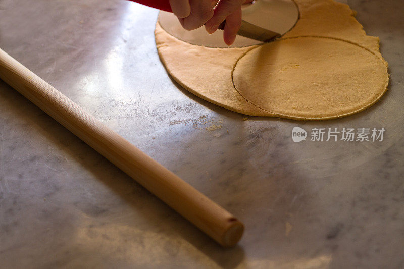 在大理石砧板上手工切馅饼皮