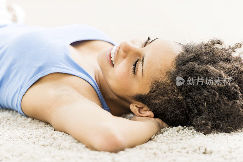 微笑的女人躺在地毯上。