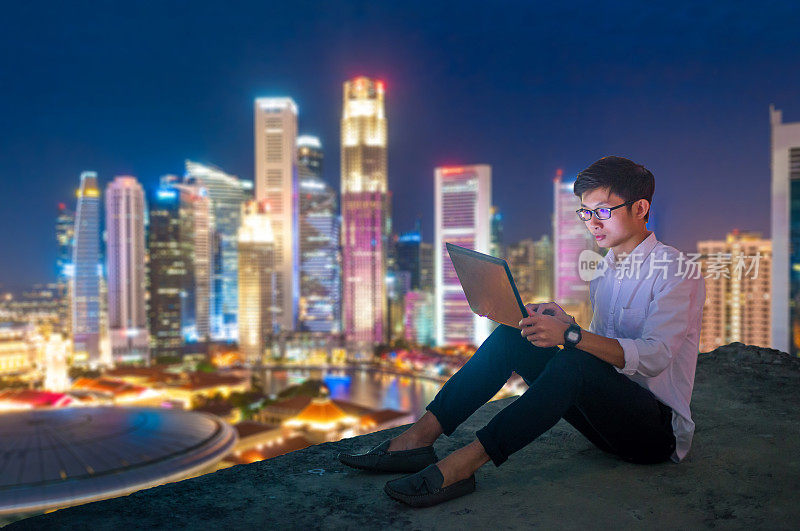 在新加坡使用笔记本电脑和数字平板电脑的亚洲商人