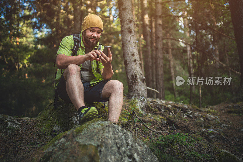旅行者在森林中使用智能手机