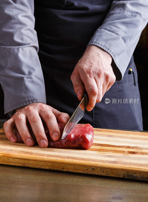 厨师在餐厅厨房的木板上切菲力牛排