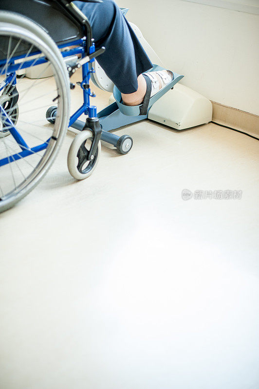 近距离观察老年妇女在轮椅上锻炼自行车