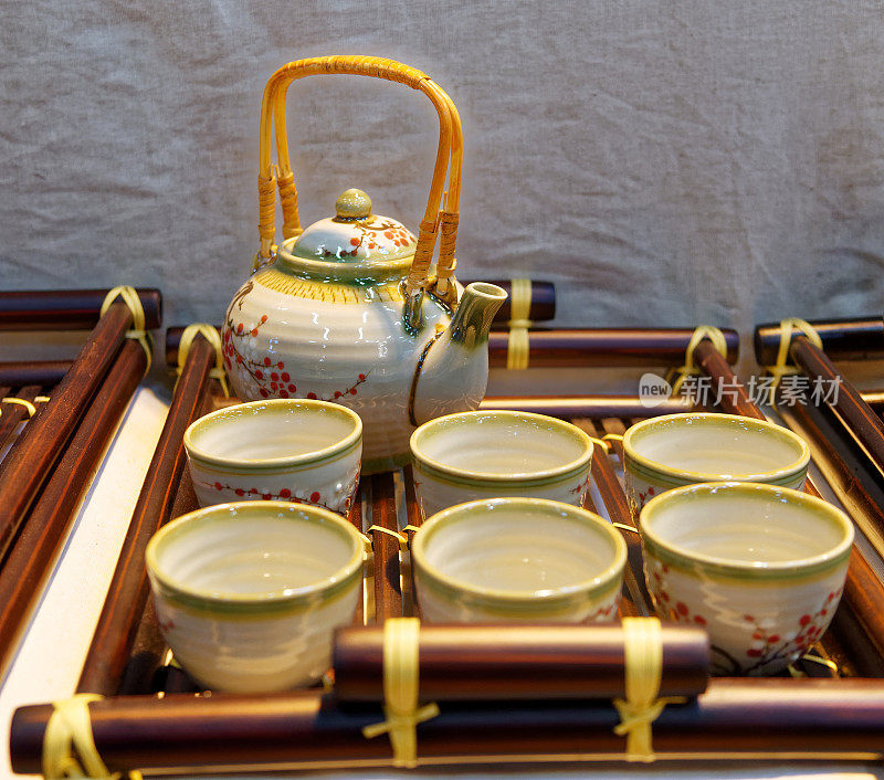 木制三脚架上的中国白色茶壶和茶杯