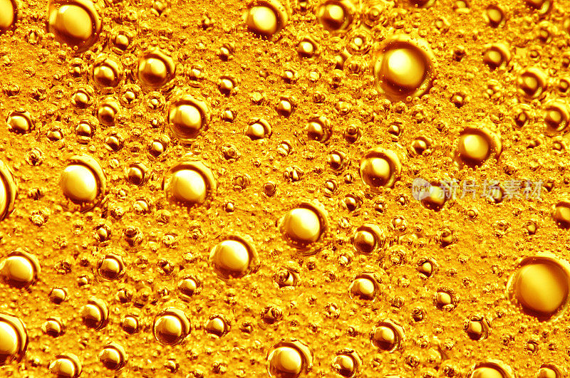 金色的背景与大的和小的金色气泡油里面的黄金液体。