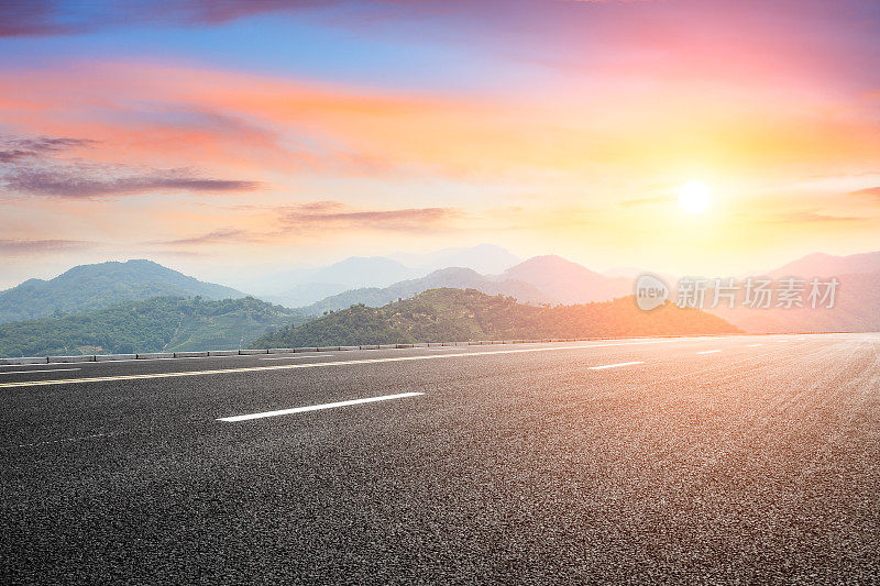 日落时，柏油路和山峦与雾蒙蒙的风景