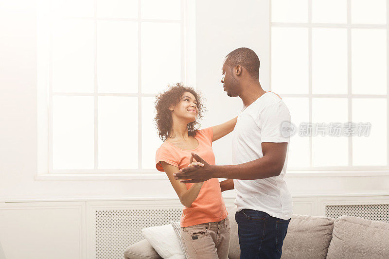 年轻的黑人情侣在家里跳舞，拷贝空间